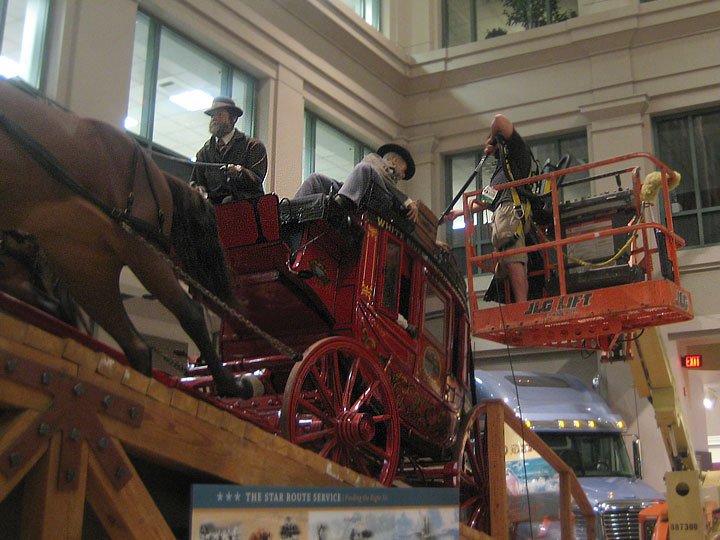 a man vacuuming a red wagon in the museum's lobby