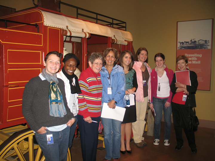 Docents posing in front of a stage coach