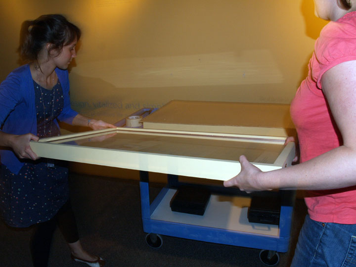 Irene and Caitlin using their muscles to move the frame onto the cart