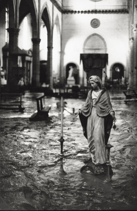 A statue of Saint Mary amid flood waters in a church