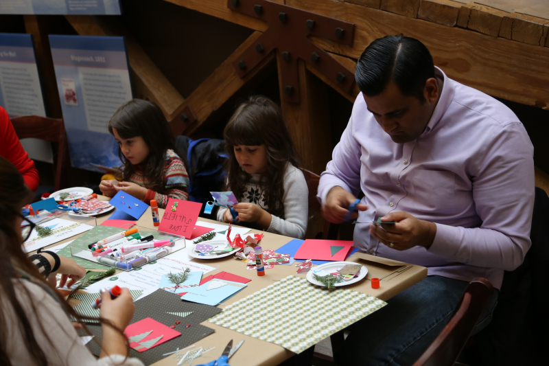 Museum visitors enjoying holiday card crafting