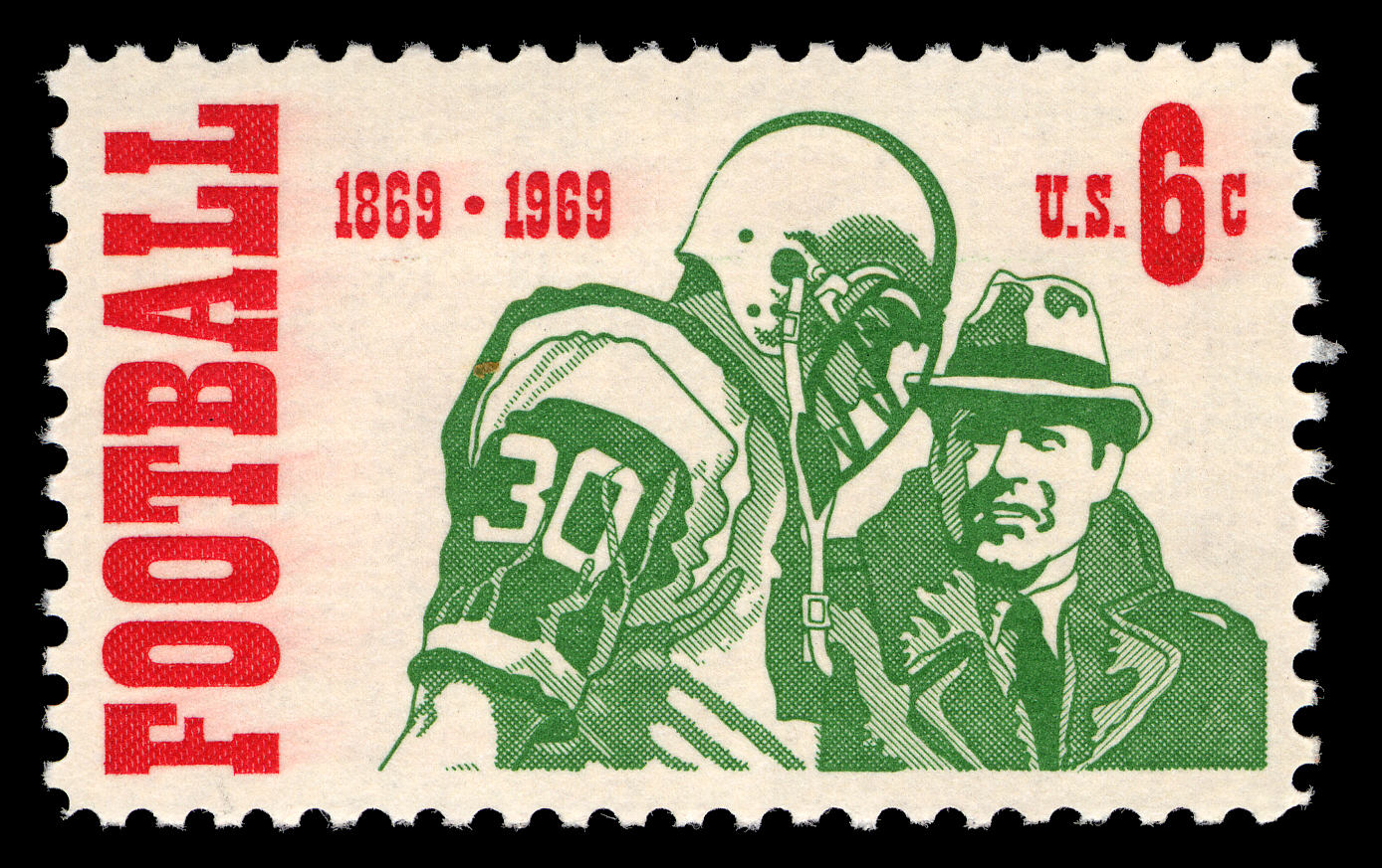 Postage stamp with image of football player in uniform standing next to man in hat and coat, presumably the coach.