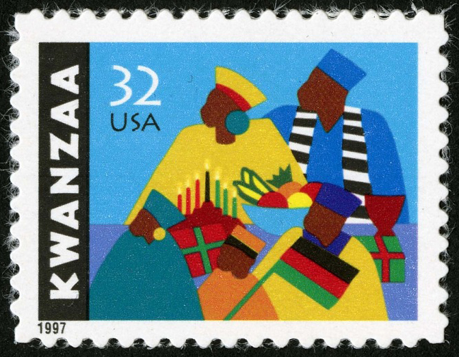 U.S. postage stamp with illustration of African American family – a mother, father, and three children—dressed in vibrant hats clothing with presents, a bowl of fruit, and a lit Kwanzaa kinara