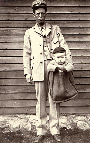 https://postalmuseum.si.edu/sites/default/files/letter-carrier-with-child-in-mailbag1.jpg