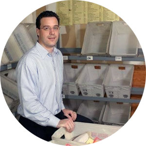 Adam standing surrounded by mail bins