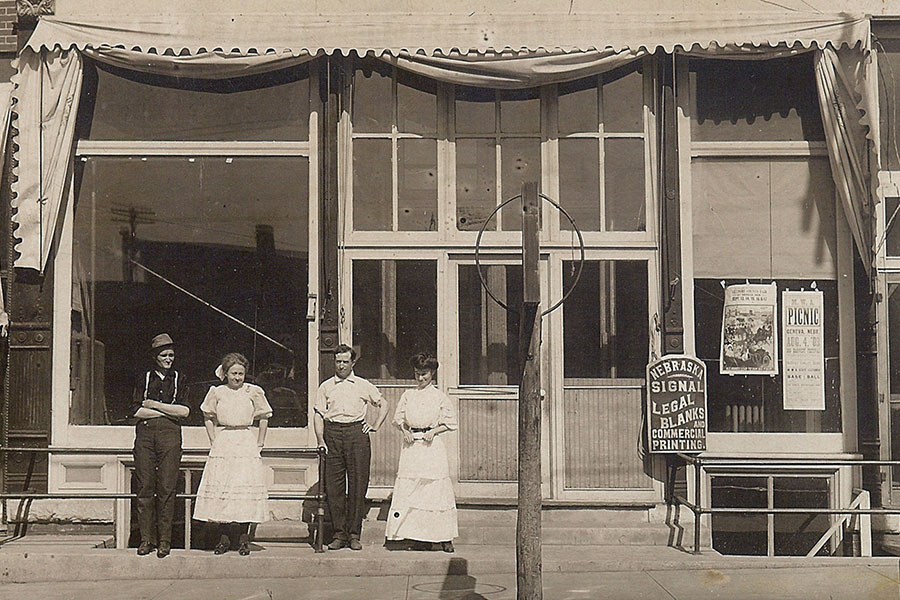 Four people stanging in front of Signal building in 1908.