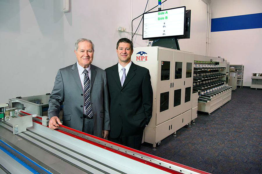 Henry and Brent Daboub standing in next to printing machinery