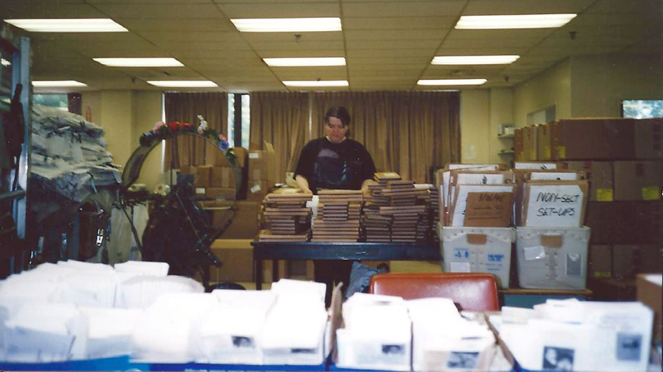 Woman working with small packages in a mail shop.