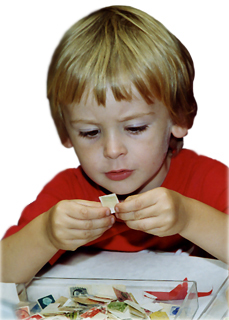 A boy looking closely at a postage stamp