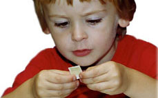 A boy looking closely at a postage stamp